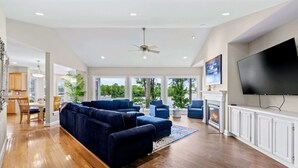 A spacious living room with a large sectional sofa, a flat-screen TV, and a fireplace. - Lakefront Lake Anna, Views, Boat Dock, Hot Tub (Mineral)
