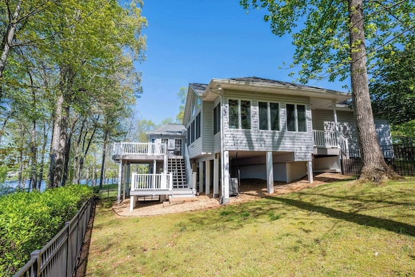 A two-story house with a covered porch and a small deck.