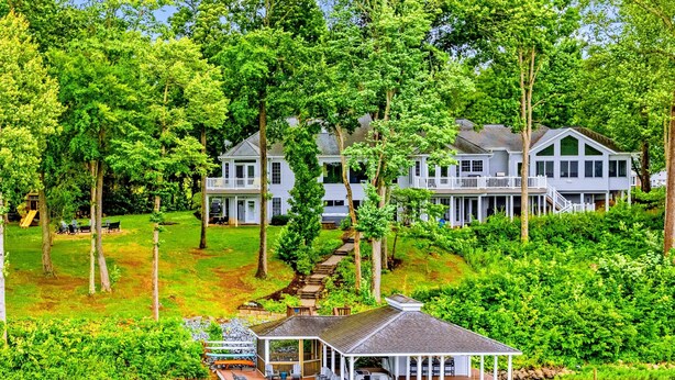 A lakeside property with a dock, a covered seating area, and a large house with multiple levels. - Lakefront Lake Anna, Views, Boat Dock, Hot Tub (Mineral)