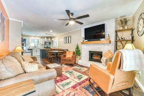 A living room with a fireplace, a ceiling fan, and a television mounted above it. - Private Hot Tub & Deck: Gaylord Family Home! (Gaylord)
