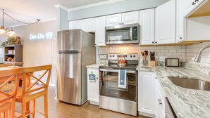 A modern kitchen with stainless steel appliances, white cabinetry, and a marble countertop. - Golf, Shop & Relax Beachside! Hilton Head Getaway (Hilton Head Island)