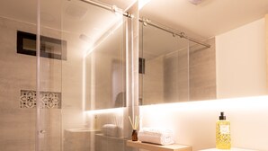 A modern bathroom with a glass-enclosed shower, a white toilet, and a wooden vanity. - Mishka Hotel Boutique (Cartagena)
