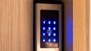 A modern door lock with a keypad and a card slot, mounted on a wooden door. - Mishka Hotel Boutique (Cartagena)