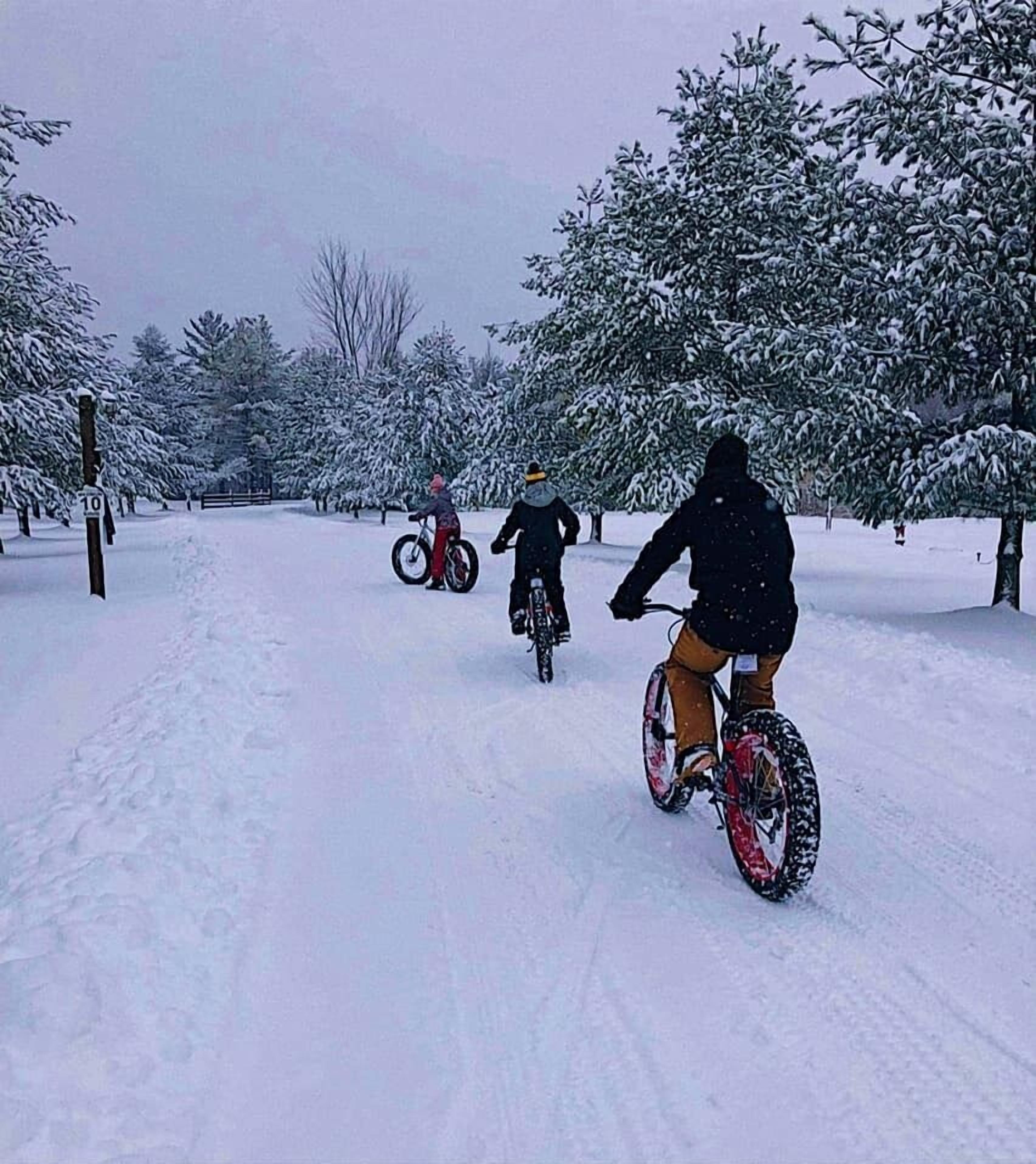 Un sendero cubierto de nieve con ciclistas.
