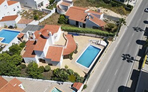 Ett bostadsområde med flera hus, en swimmingpool och en väg.