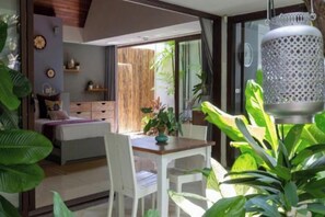 A modern bedroom with a bed, bedside table, and a large window. - Chic Baan Capo - Luxury Four Bedroom Beachfront Villa (Koh Samui)