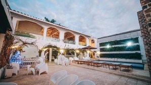A courtyard with a pool, outdoor seating, and a covered area with arches. - Angel de Santa Fe by Bernalo Hotels (Santa Fe de Antioquia)