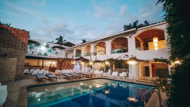 A poolside area with lounge chairs, a dining table, and a pool. - Angel de Santa Fe by Bernalo Hotels (Santa Fe de Antioquia)