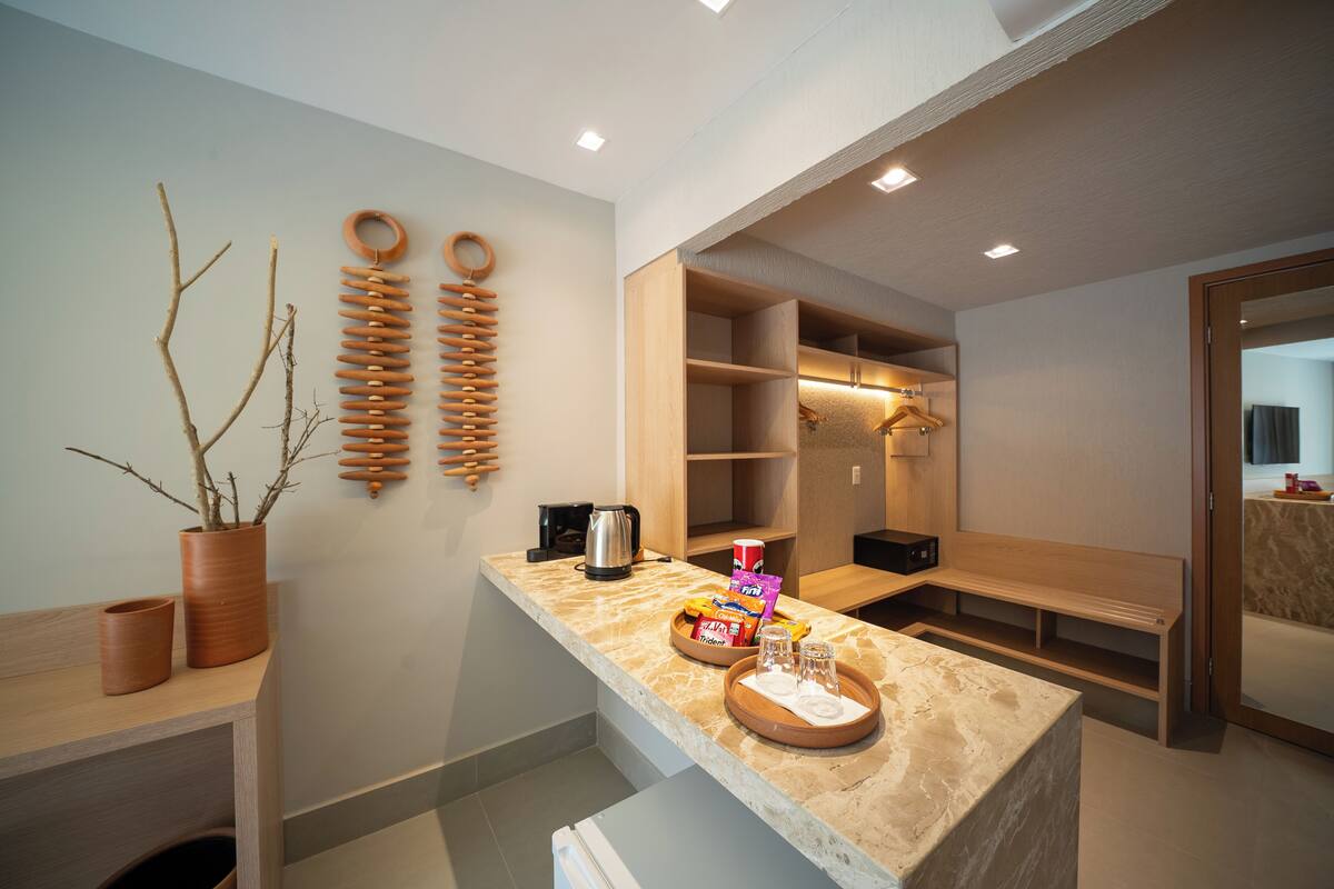 Une salle de bain moderne avec un comptoir en marbre, des étagères en bois, un banc et un miroir.