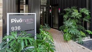 A modern building entrance with a sign for 'Pivomatch 936.' - Pivô Pamplona by Viva - Apartamentos novos e espaçosos ao lado da Av Paulista (São Paulo)