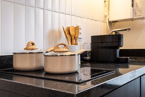 A kitchen with two pots on the counter, a toaster, and wooden utensils in a holder. - Pivô Pamplona by Viva - Apartamentos novos e espaçosos ao lado da Av Paulista (São Paulo)