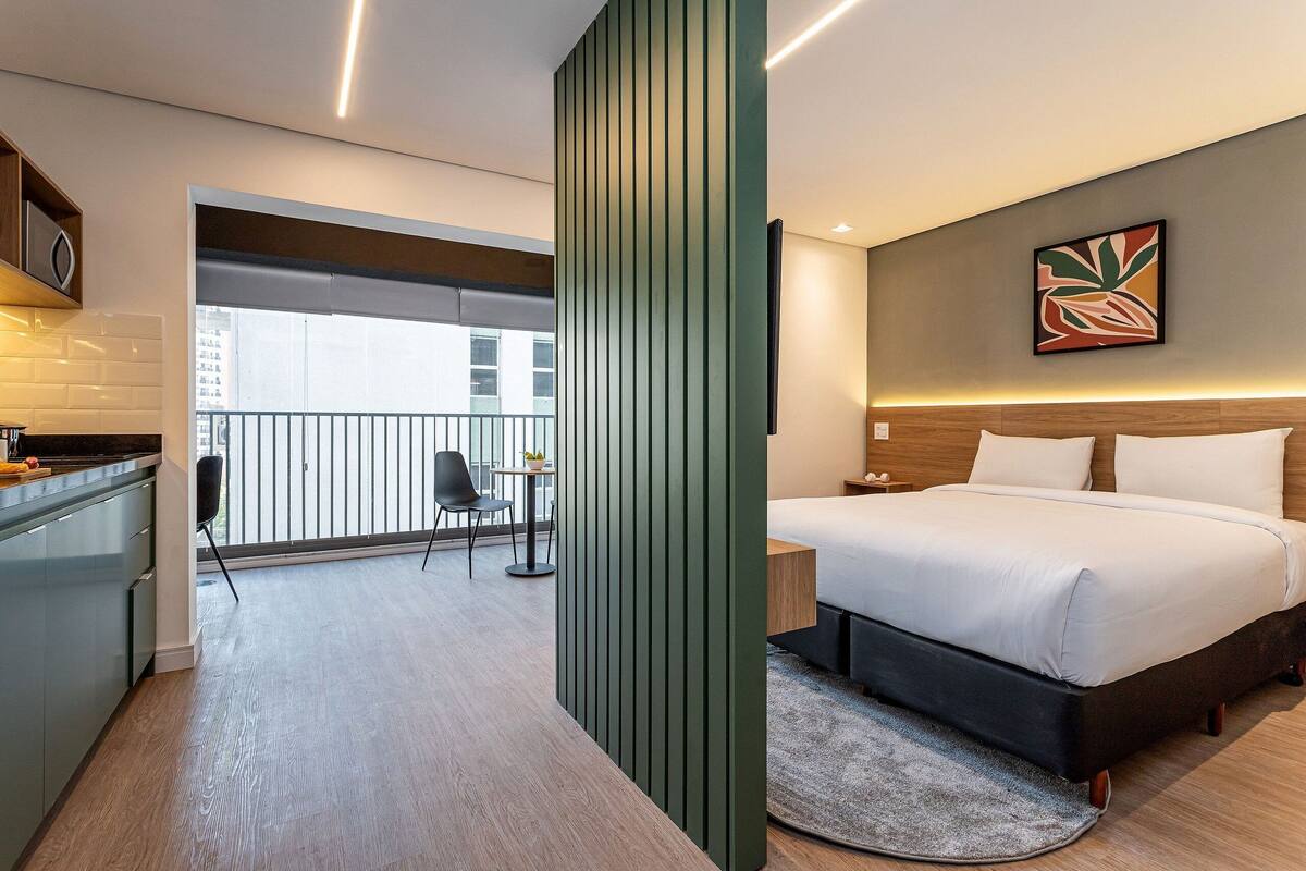 Une chambre d’hôtel moderne équipée d’un lit, d’un bureau, d’une chaise et offrant une vue sur la ville.