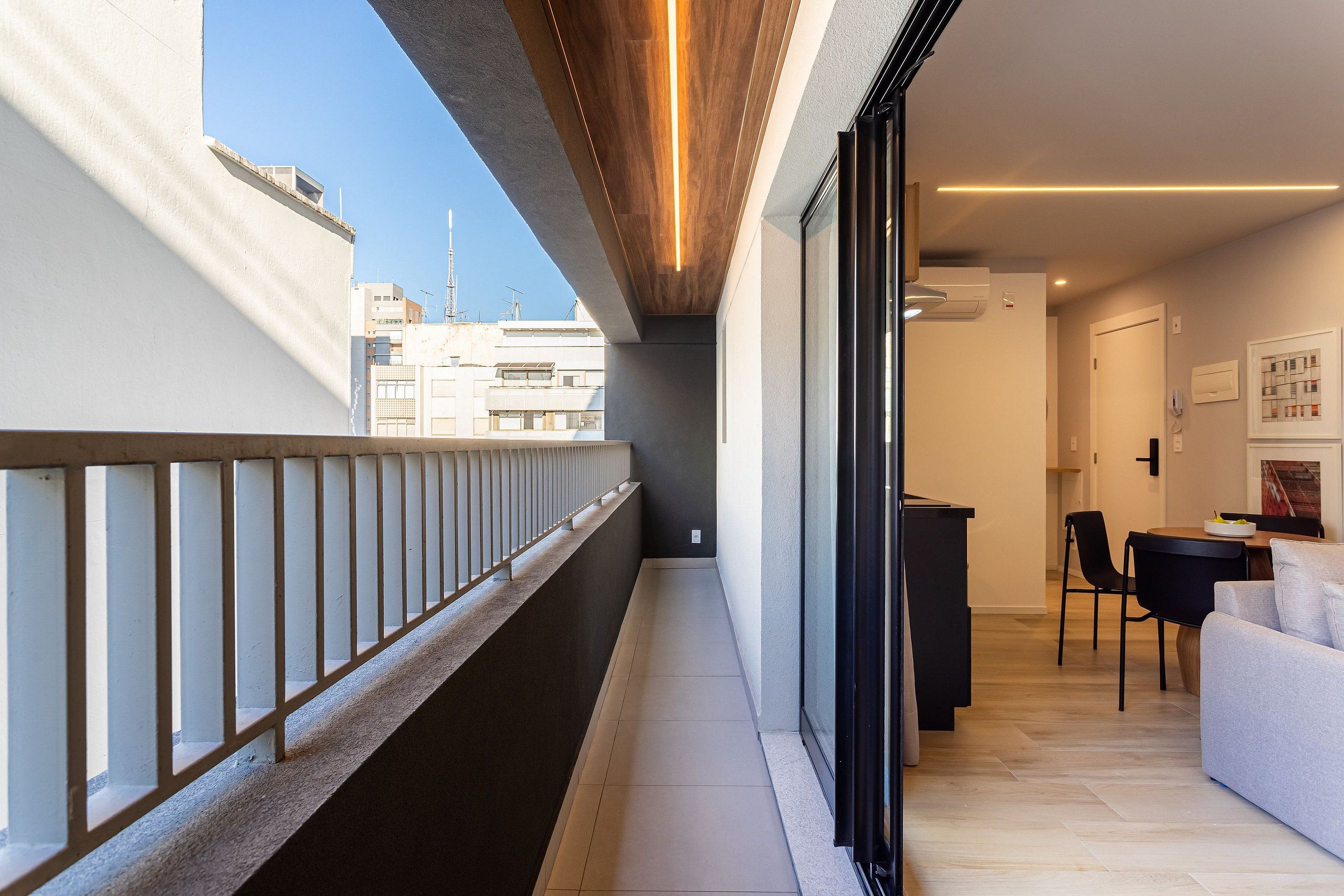 Un appartamento moderno con un balcone, zona pranzo e cucina.