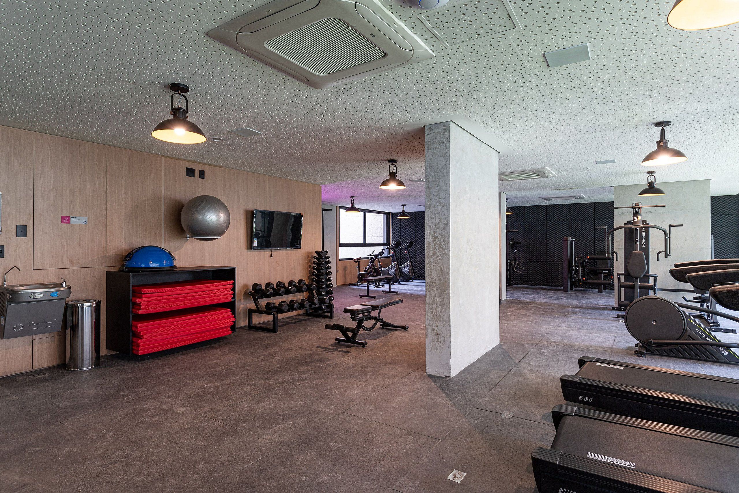 A gym with treadmills, weights, and exercise equipment.