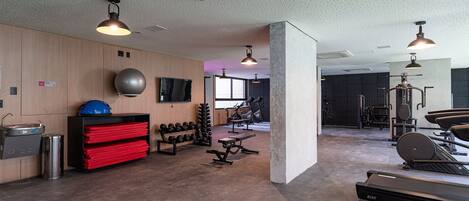 A gym with treadmills, weights, and exercise equipment.