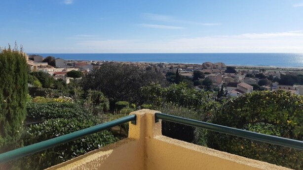 A balcony with a view of a coastal town and the sea. - 1-bedroom studio with sea view. Ideal for 2 adults and 1 child. (Saint Pierre la mer)