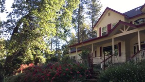 A two-story house with a stone staircase leading to a porch.