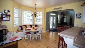 A dining area with a round table, chairs, and a chandelier. There is a sign reading "Moms Diner" on the wall.