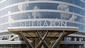 Et moderne Sheraton hotel med en karakteristisk X-formet indgang og store glasfacader.