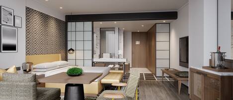 Een moderne hotelkamer met een bed, een zithoek, een kitchenette en een televisie.