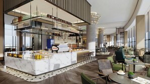 En moderne hotellobby med en receptionsdisk i marmor, siddepladser og store vinduer.