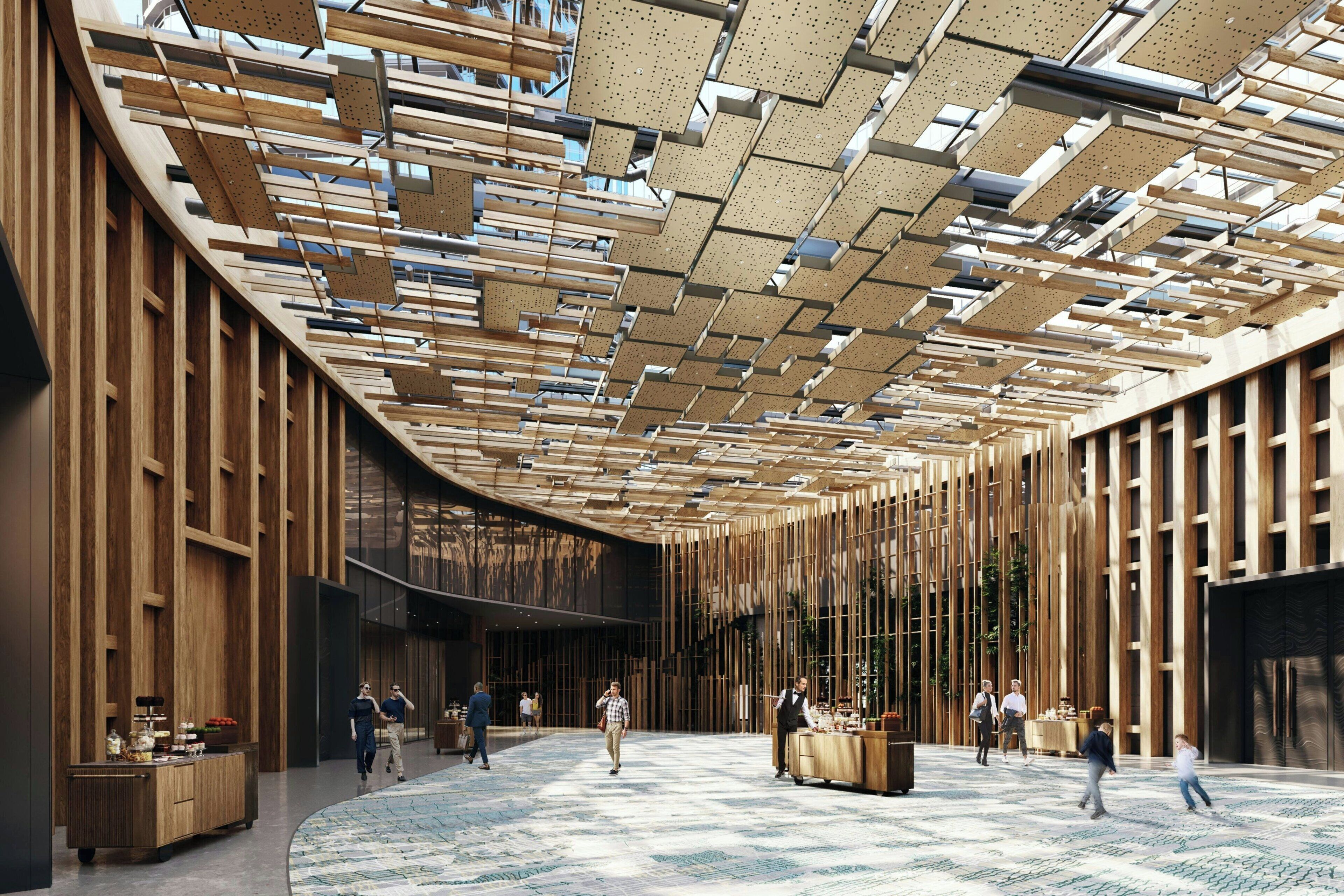 Eine großzügige Lobby mit hoher Decke und Holzlamellen-Design, einer zentralen Sitzgruppe und einem gemusterten Boden.