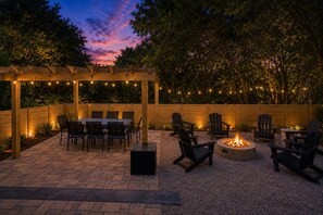 Une terrasse extérieure dotée d’une pergola, d’un foyer et d’un espace aménagé pour s’asseoir.