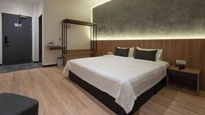 A modern bedroom with a large bed, wooden headboard, bedside tables, and a mirror. - Blu Sentral Hotel (Tawau)