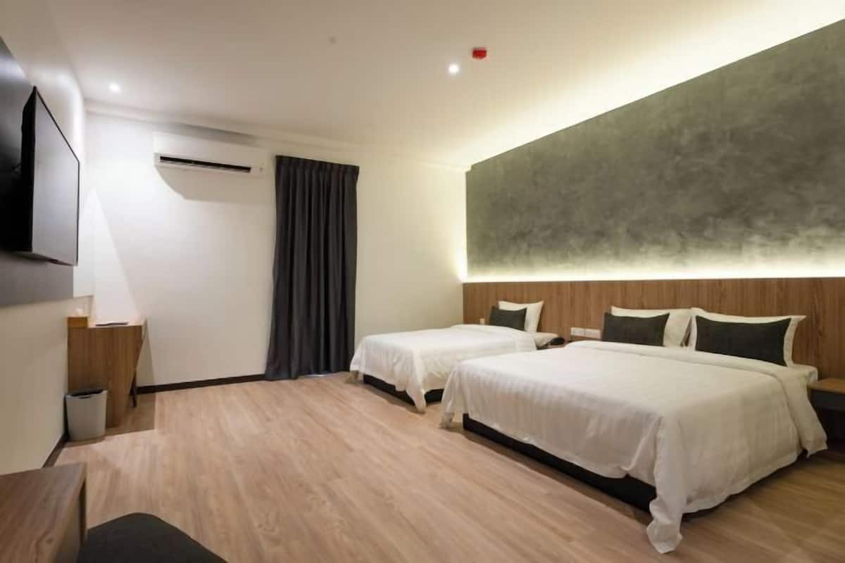 A hotel room with two beds, a flat-screen TV, a desk, and a large abstract wall art piece.