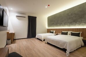 A hotel room with two beds, a flat-screen TV, a desk, and a large abstract wall art piece. - Blu Sentral Hotel (Tawau)