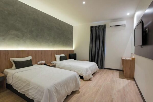 A hotel room with two beds, a flat-screen TV, an air conditioning unit, and a wooden floor. - Blu Sentral Hotel (Tawau)