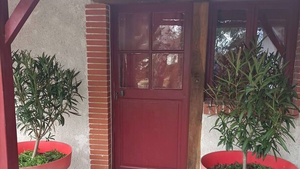 A red door with a small porch and two large potted plants on either side. - Coquette and independent room, 2 steps from Chambord, the castles and Beauval (Tour-en-Sologne)