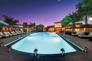 A swimming pool with lounge chairs and umbrellas, surrounded by palm trees and buildings. - 3BDR Near Disney/Private Jacuzzi/No Resort Fee/Free Parking &Wi-Fi/Shared Pool (Kissimmee)