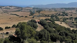 A rural landscape with rolling hills, scattered trees, and a small building with a red roof. - Panorama Residence swimming pool 2 bedrooms (San Giovanni)