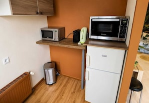 A compact kitchenette with a microwave, toaster, and a small refrigerator.