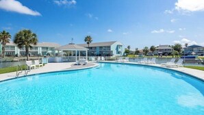 A swimming pool with lounge chairs and a gazebo, surrounded by buildings with a light blue facade. - Waterfront Luxury Condo (Rockport)