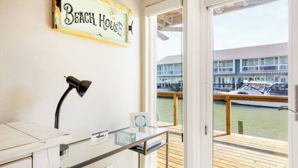 A room with a desk, a lamp, and a sign reading "Beach House". - Waterfront Luxury Condo (Rockport)