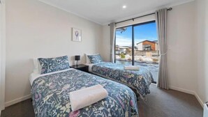 Une chambre d’hôtel avec deux lits, une grande fenêtre et une vue sur l’extérieur.