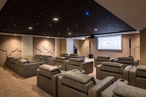 A home theater with reclining seats, a starry ceiling, and a projector screen. - Sunway Sanctuary - Seniors Hotel & Residences (Subang Jaya)