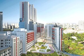 Un área urbana moderna con rascacielos, un patio central con vegetación y un puente peatonal.