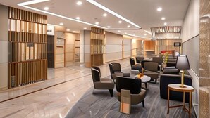 A modern hotel lobby with a central seating area, a reception desk, and a decorative wall with vertical panels. - Sunway Sanctuary - Seniors Hotel & Residences (Subang Jaya)