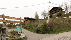 A rustic chalet with a stone pathway leading to it, surrounded by greenery and sheep grazing. - CHALET LE TREDARD - FEISSONS SUR SALINS (FEISSONS SUR SALINS)