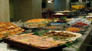Noutopöytä, jossa on tarjolla monenlaista ruokaa, kuten mereneläviä, salaatteja ja leipää.