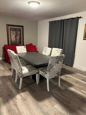 A dining area with a rectangular table and four chairs, each with a floral pattern. - Cozy 6-Person Cottage Near I-75 (Sumner)