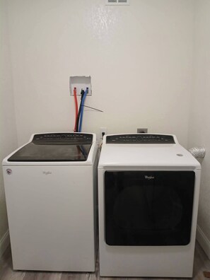Two white Whirlpool dryers side by side with a power outlet and cables above them. - Cozy 6-Person Cottage Near I-75 (Sumner)