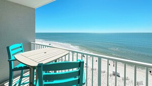 Un balcon avec vue sur la plage et l’océan.