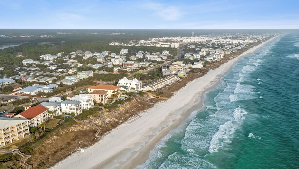 An aerial view of a coastal residential area with beachfront properties, a sandy beach, and ocean waves. - 2 BR Cottage in 30A | Outdoor Pool, 2 Bikes | My Beach Getaways (Inlet Beach)