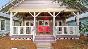A house with a porch, two red Adirondack chairs, and a wooden deck. - 2 BR Cottage in 30A | Outdoor Pool, 2 Bikes | My Beach Getaways (Inlet Beach)