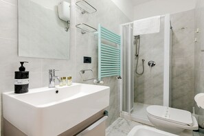 Chuveiro, secador de cabelo, bidê, toalhas de banho