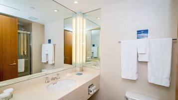 Un bagno moderno con un ampio specchio, due lavabi e un water.